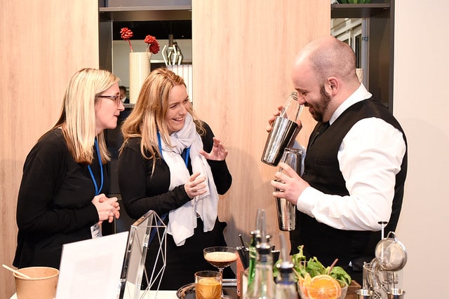 Cocktail Bartender shaking cocktail with guests