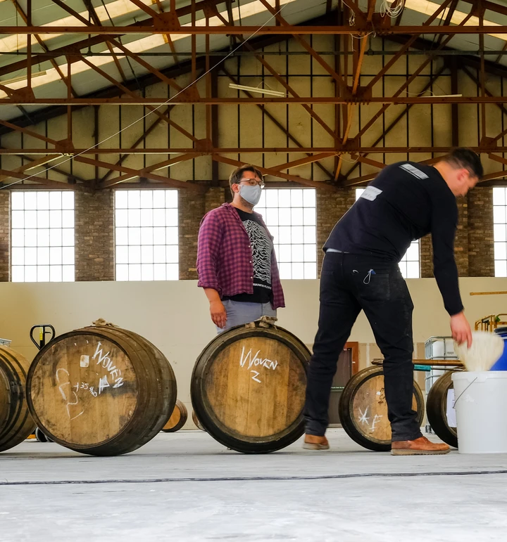 Woven Whisky team rolling barrels of whisky