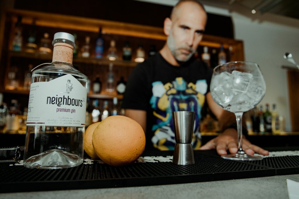 A bartender mixing a cocktail with ingredients on the bar