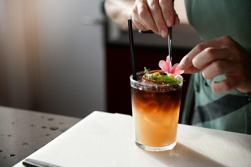 A mixologist adds garnish to a cocktail