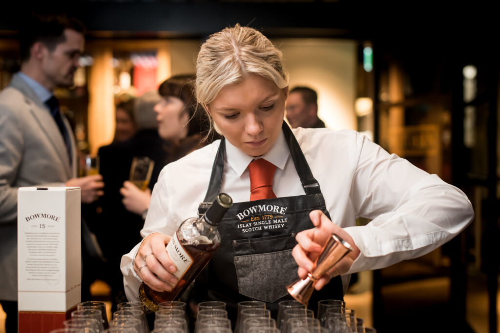 A Cocktail Service brand ambassador pouring Bowmore Whisky