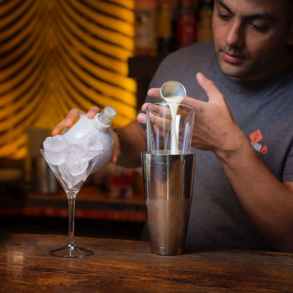 A bartender using a Boston Shaker